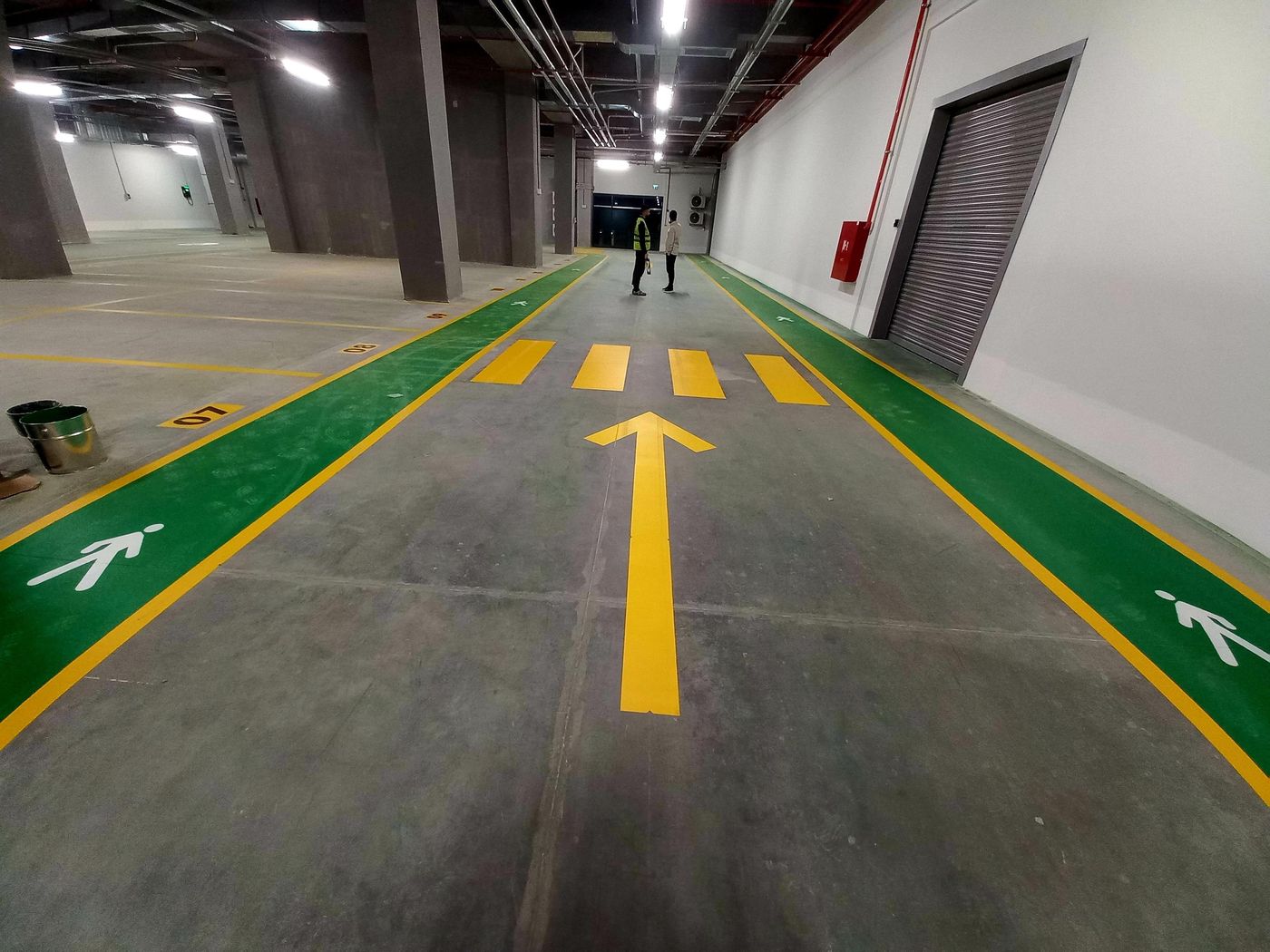 Depo içinde yeşil yaya koridorları, sarı yön oku ve yaya geçidi